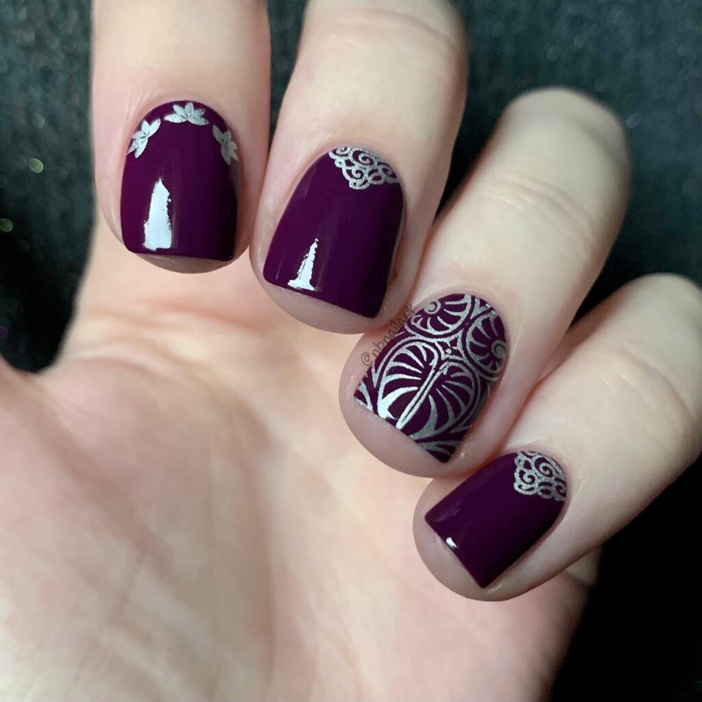 A close-up of elegant dark purple nails with matte purple and ombre nail designs, perfect for both everyday wear and Halloween.